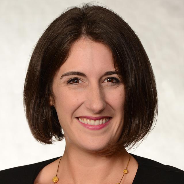 Nicole Vilkner poses for a headshot in front of a white background.