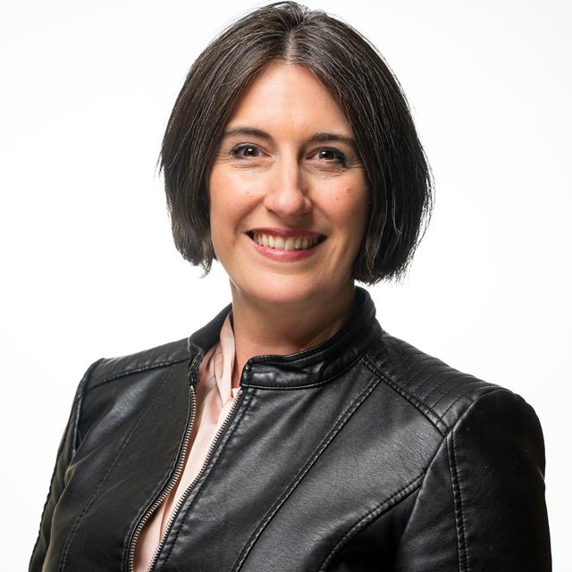 Nicole Vilkner poses for a headshot in front of a white background.