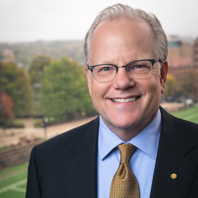 Paul Doerksen poses for a headshot in front of a blurry outdoor background.