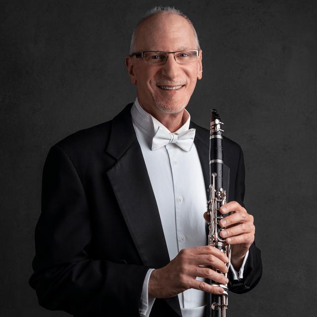 Man poses with a clarinet.