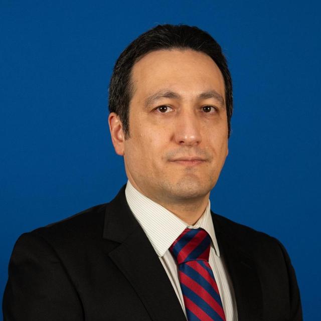 a male in a black jacket with a tie