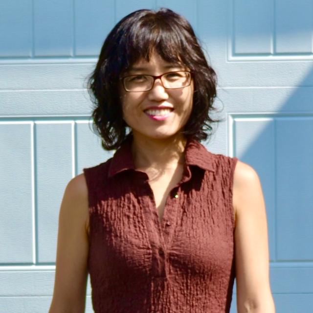 a woman with glasses and an orange blouse