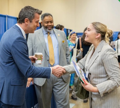 Recruiters and a student smile, shake hands, and prepare to have a conversation at a past PERC Job Fair at the Monroeville Convention Center
