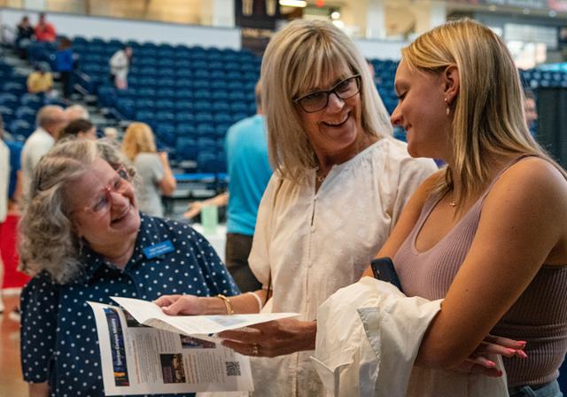 Debbie from Campus Ministry smiles at attendees at FAST