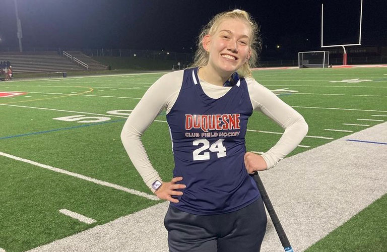 Emma Motter posing on field in Lacrosse uniform