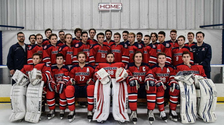 ice hockey team posing together on the ice