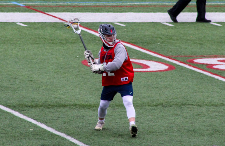 Salvatore Getty, club president, playing in a lacrosse game on Duquesne's field