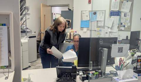 Two women looking at papers in the Health Services office.