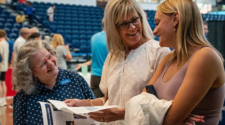 A family laughing as they talk to a staff member