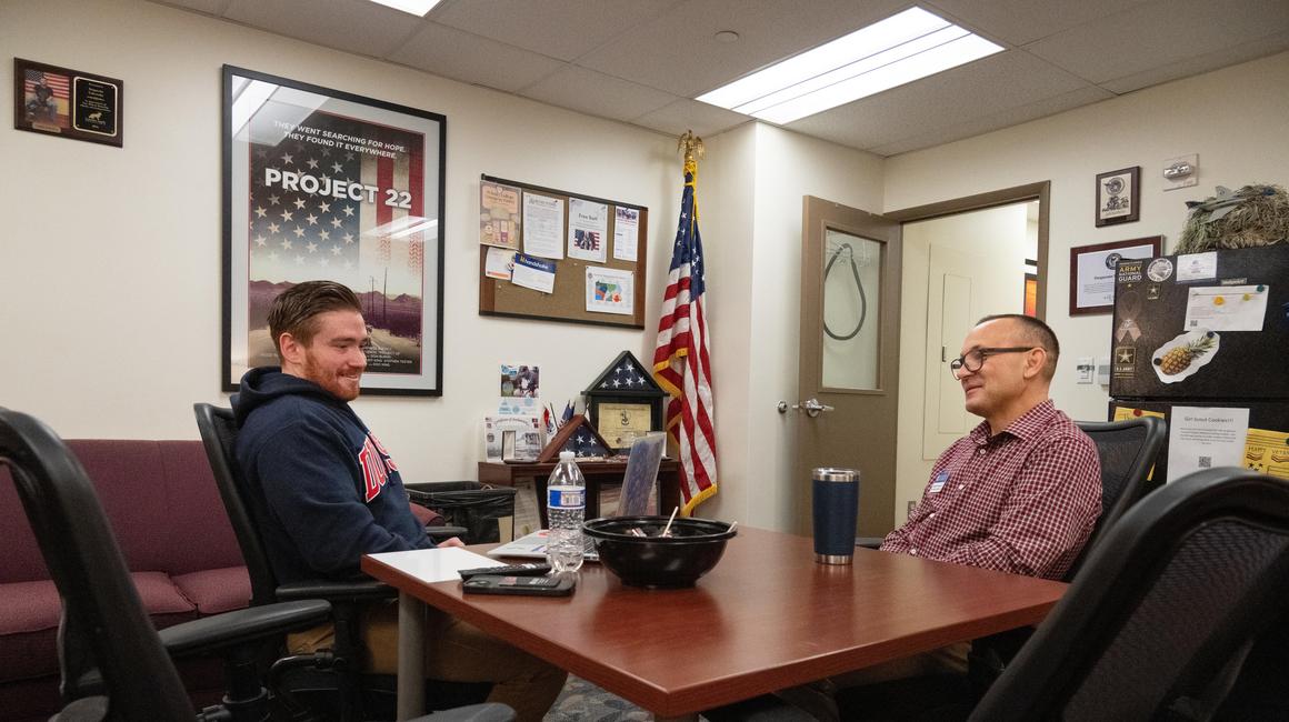 men sitting in chairs talking