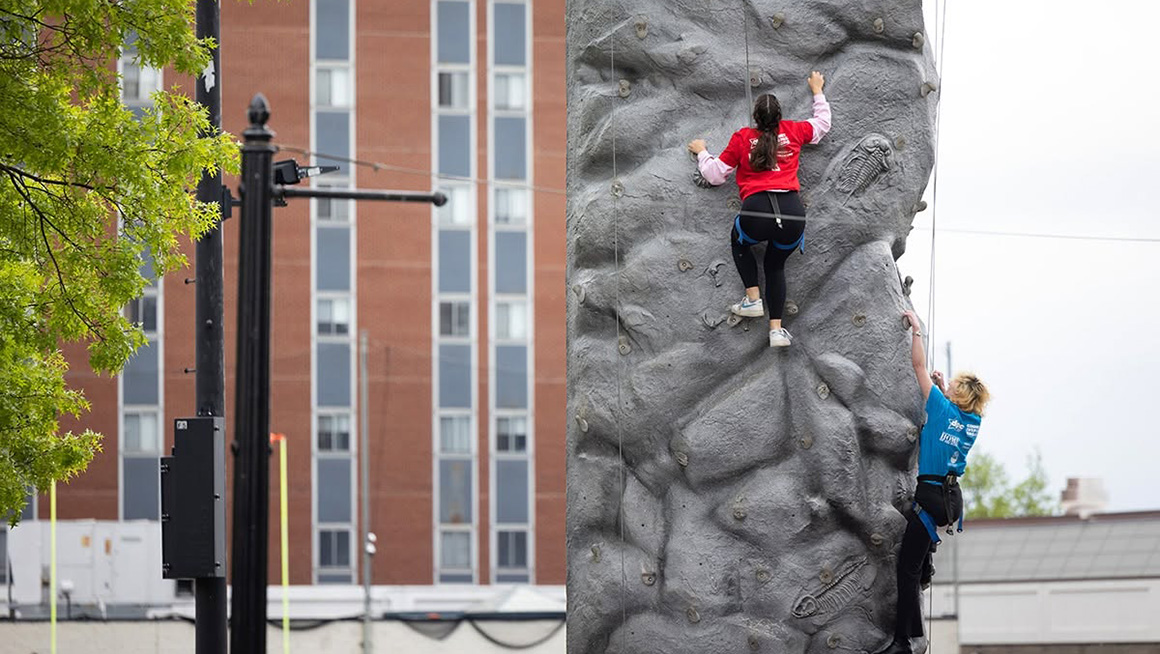 Duquesne students climbing a rock wall at Festival on the Bluff