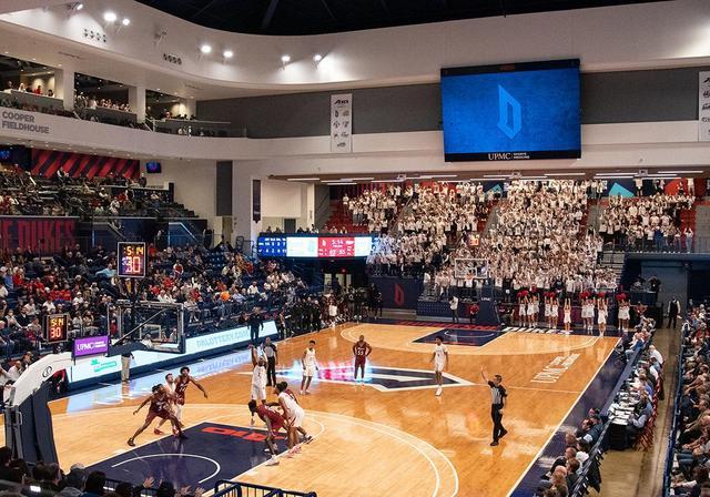Attendees are watching a Duquesne Dukes basketball game in the Cooper Fieldhouse.