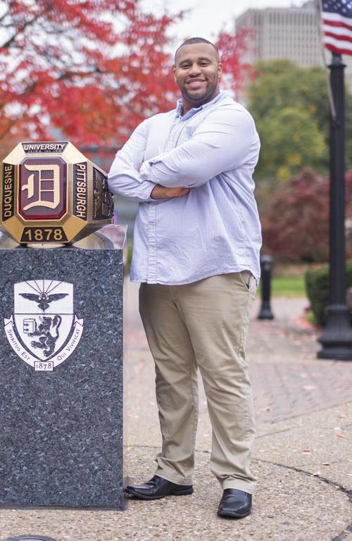 Veteran Jeffrey Brown standing next to the DU ring with the American flag in the background