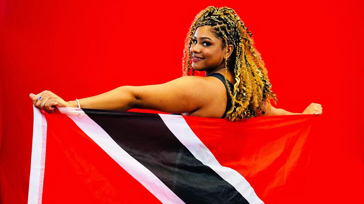 Amelia Nicholas stands with the Trinidad and Tobago flag