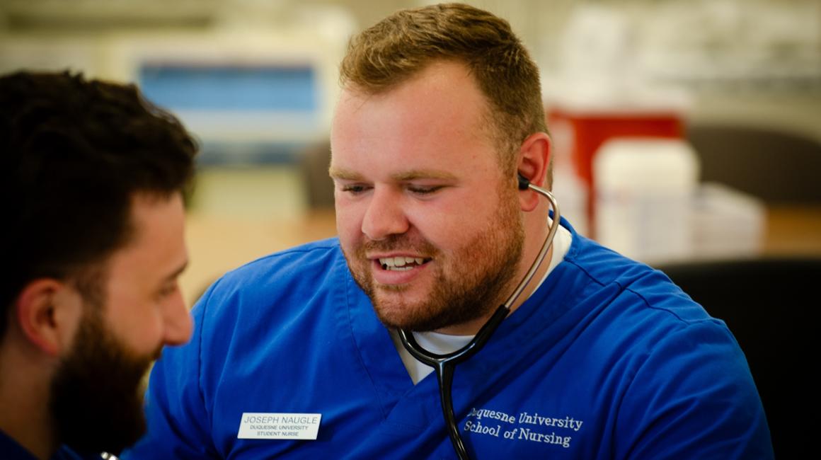 Joey Naugle taking someone's blood pressure