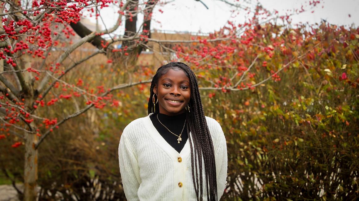Micaiah White stands in front of a bush with red berries
