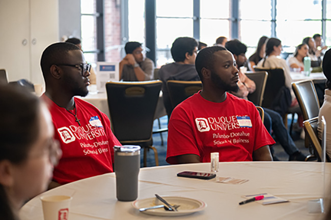 Jeromy and Welani Lamya attend International Student Orientation and sit around a table with other incoming students