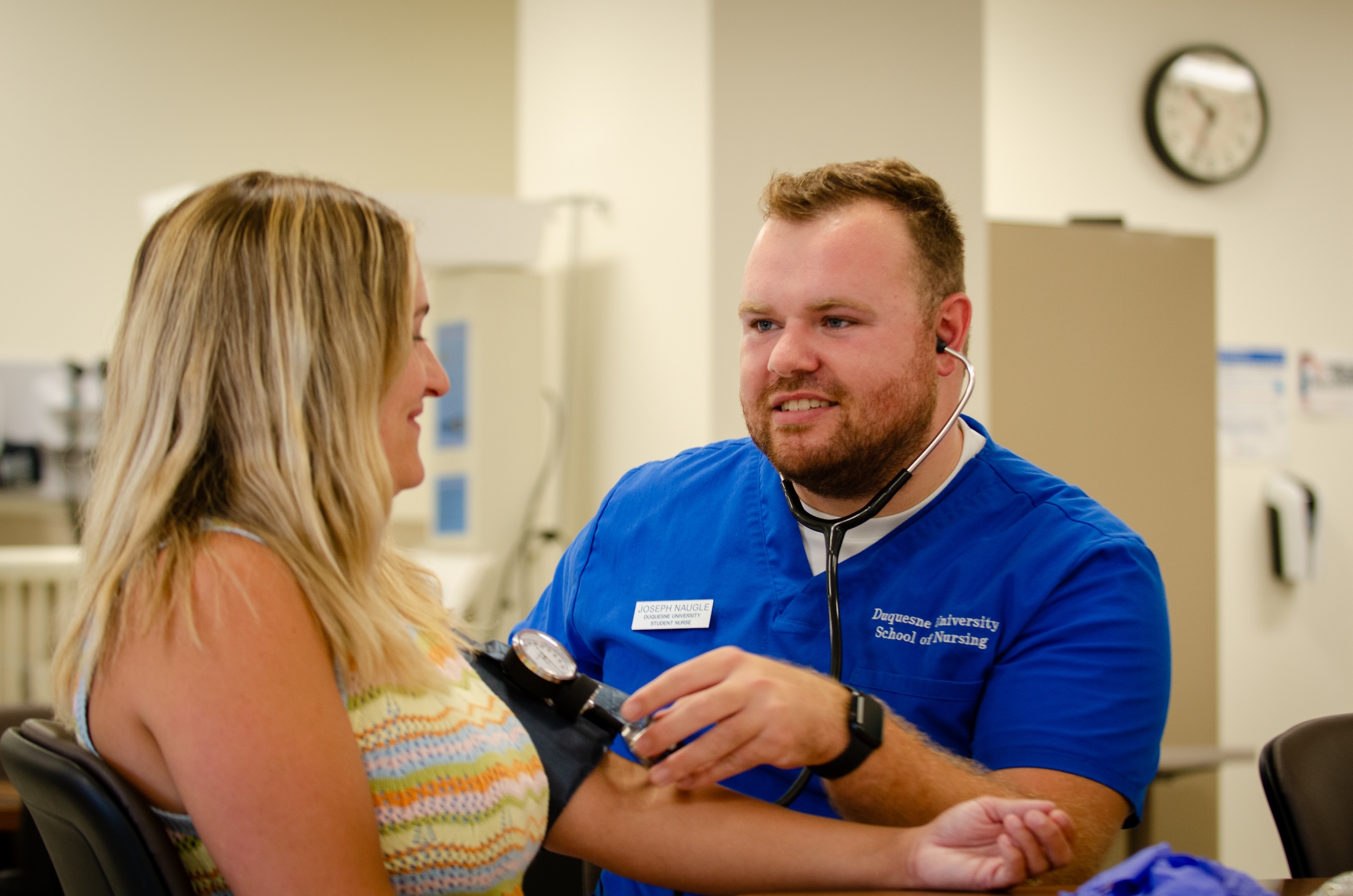 Joey Naugle takes female patient's blood pressure.