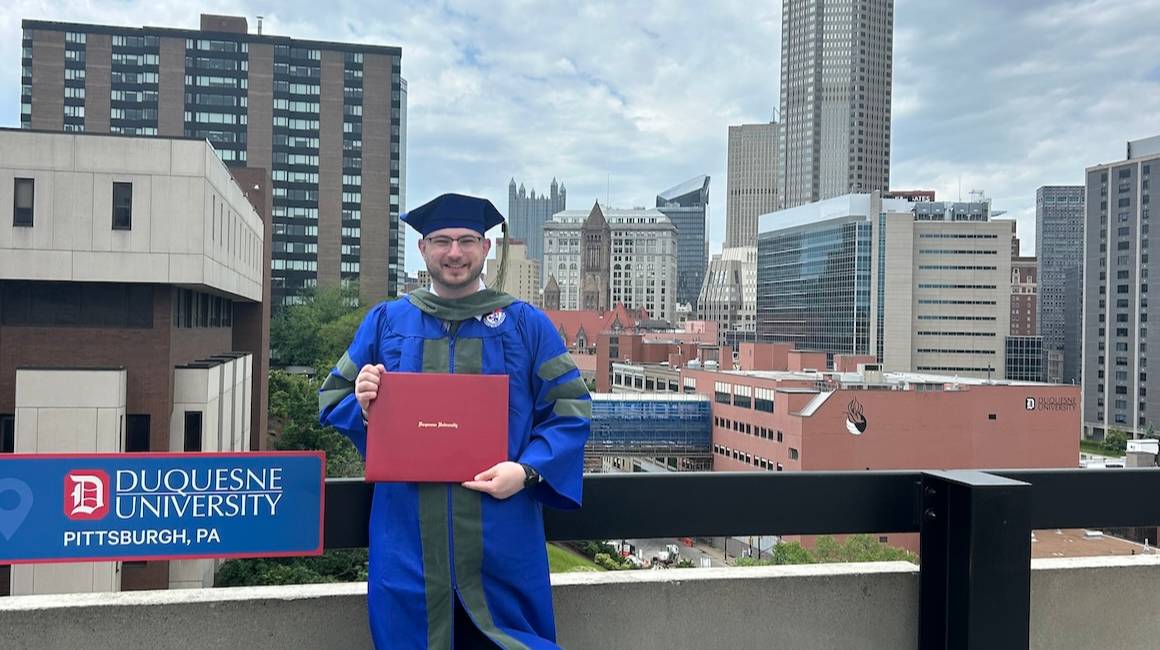Student Matt Jones holding degree.
