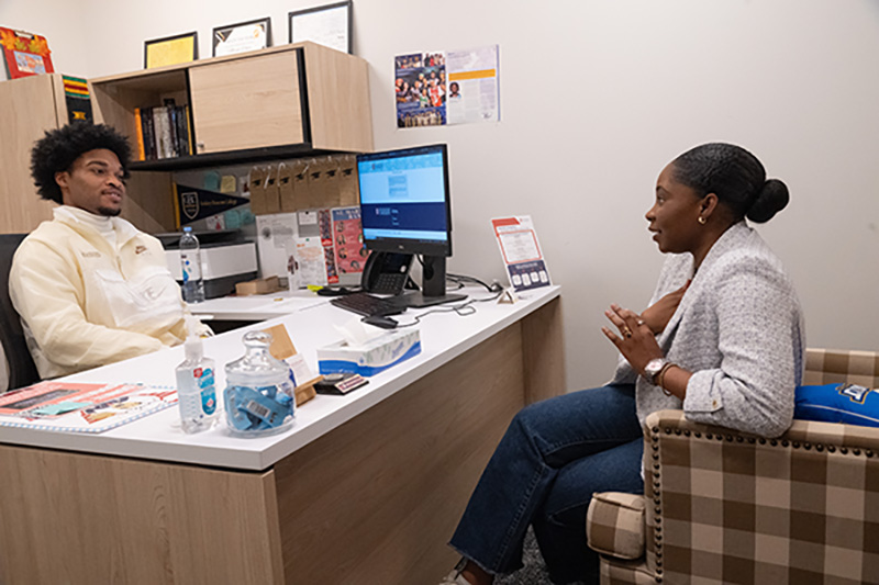St. Martin Resident Director Micah White speaks with student Saskya Hector in his office