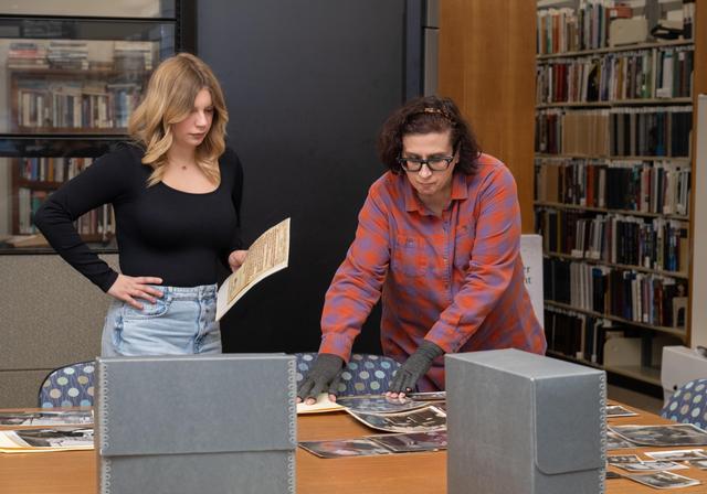 Riley views photographs of her great-grandfather alongside University assistant archivist Elisa Astorino. 