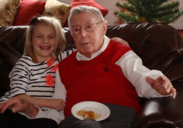 A young Riley Adams sits with great-grandfather Vernon Gallagher on a couch. 