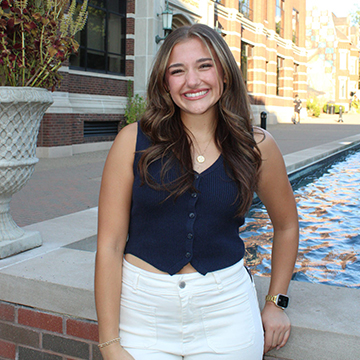 Tally Cicione smiles for the camera as she stands on Academic Walk near the fountain.