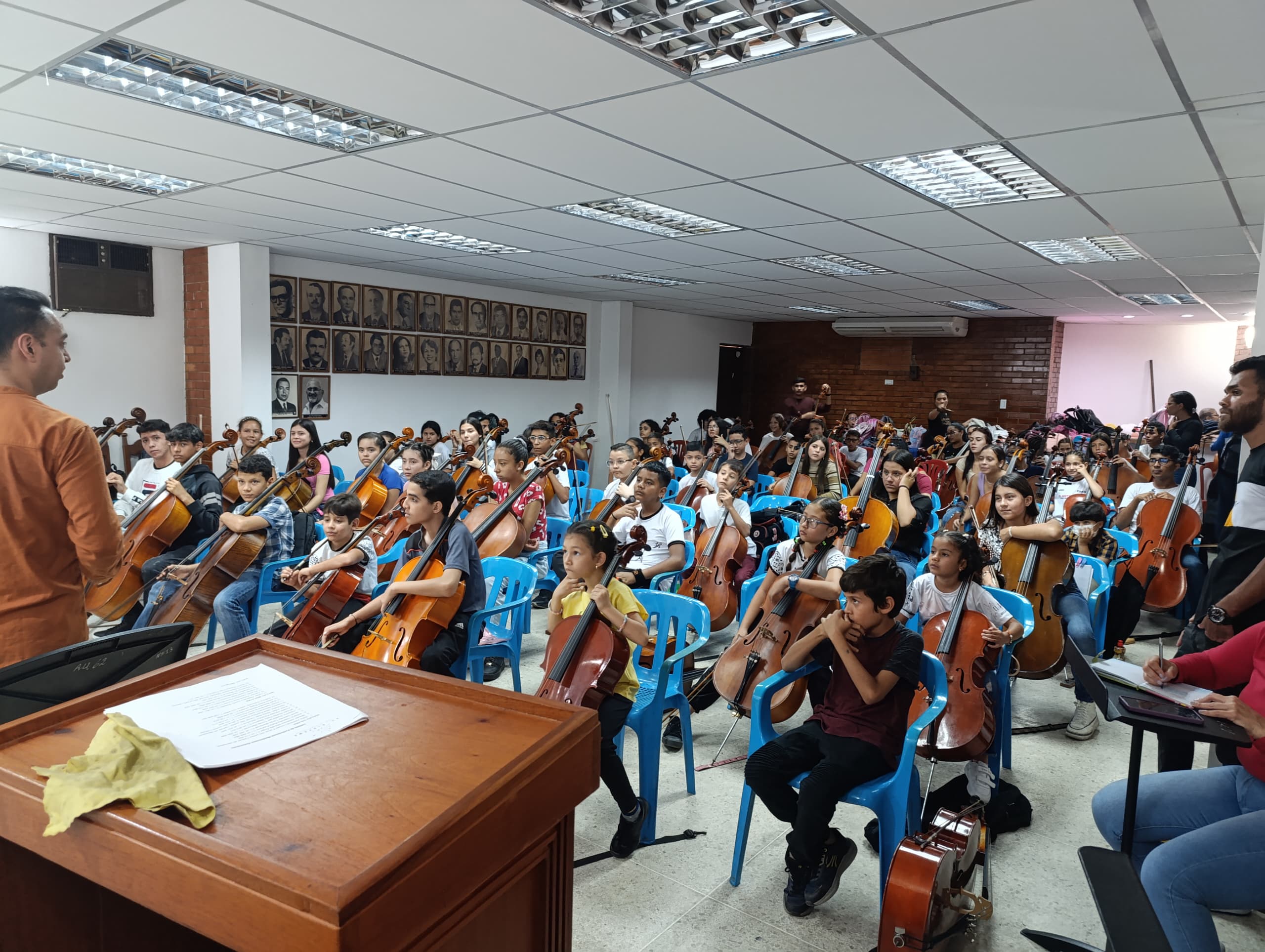 Young cellists sitting with their instruments