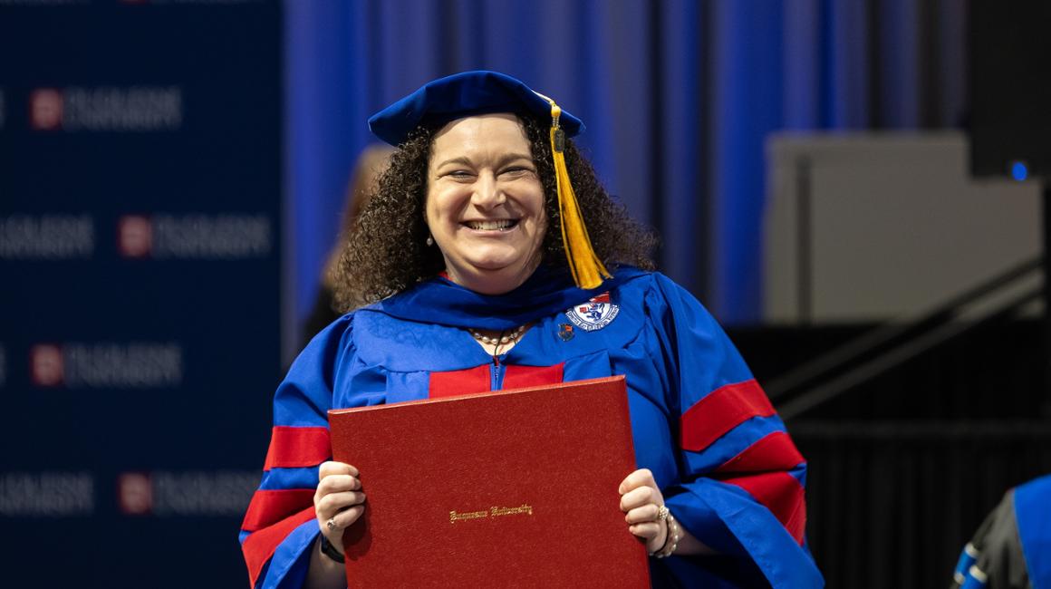 Female graduate smiling holding her diploma