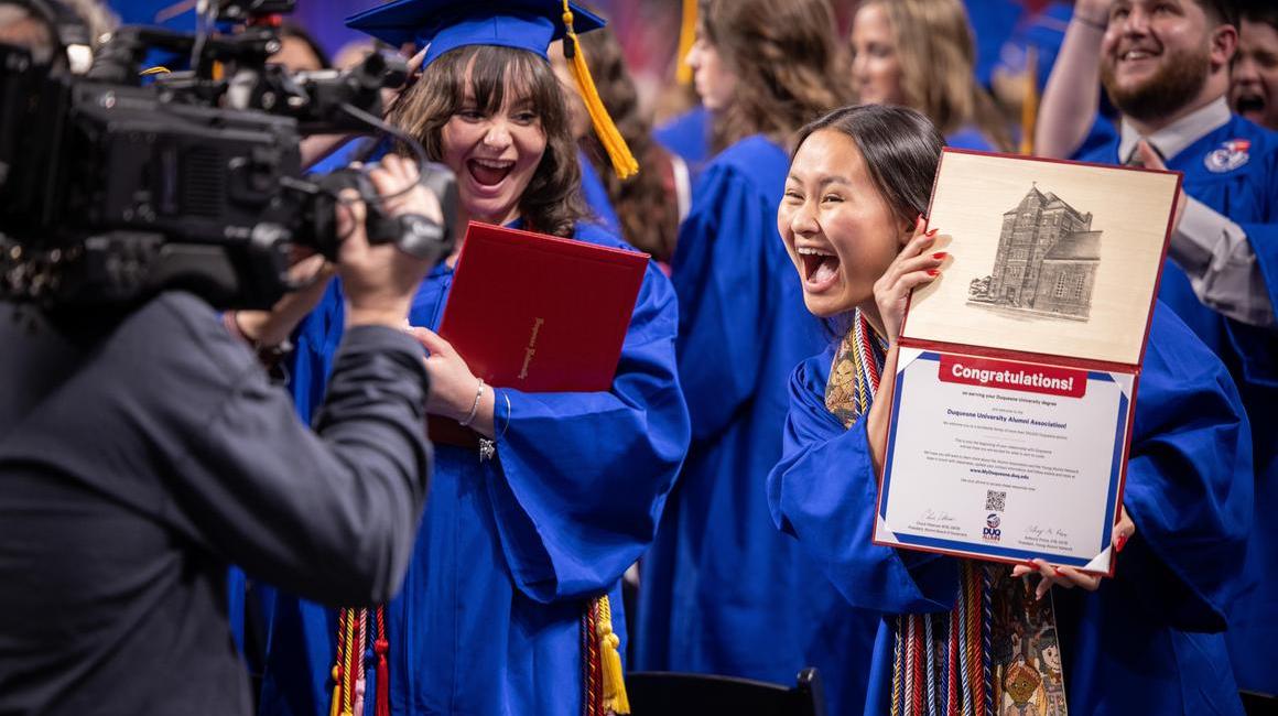 Graduate showing her diploma to videographer