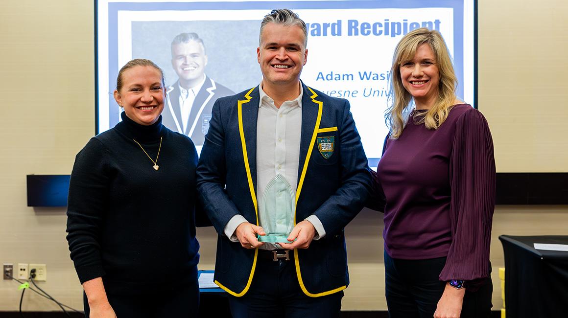 Dr. Adam Wasilko stands with colleagues as he accepts an award for outstanding First-Year Student Advocate