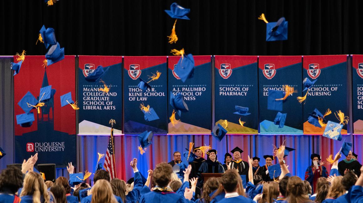 students throwing graduation caps in the air