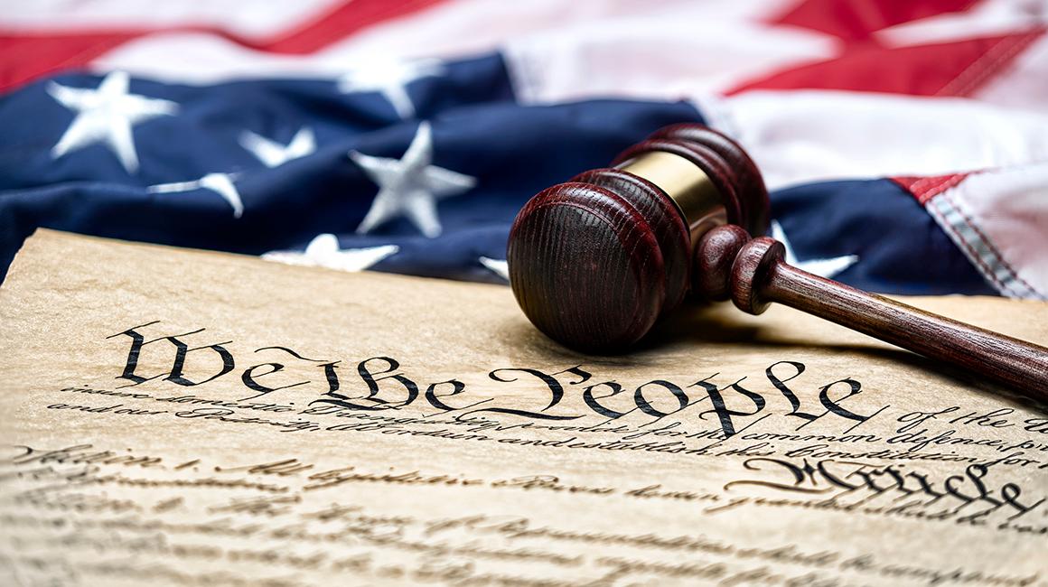 iStock image of the American flag and a gavel on top of the Constitution
