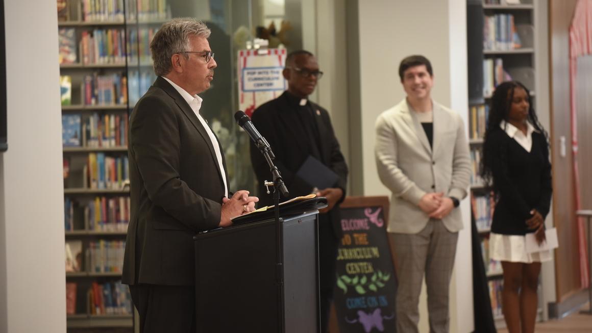 President Ken Gormley delivers remarks from a podium in front of bookshelves.