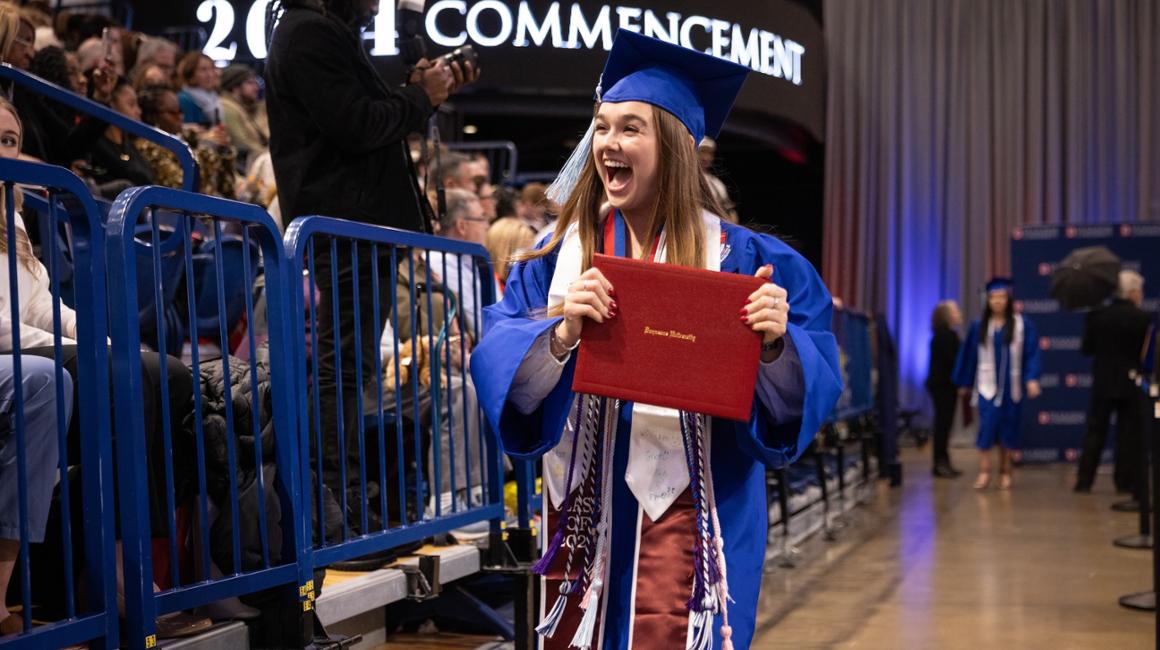 Female graduate smiles with her diploma