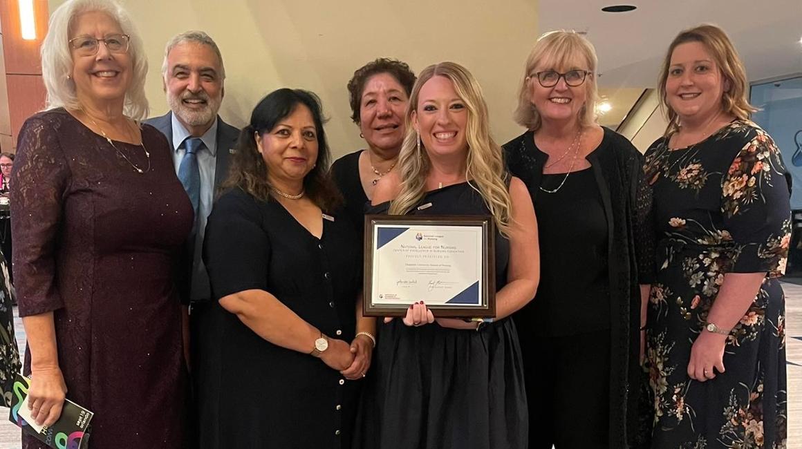 Nursing faculty and staff holding award certificate