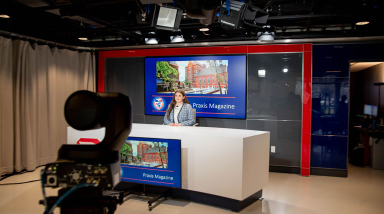 Baylee Martin working at the news desk in the studio