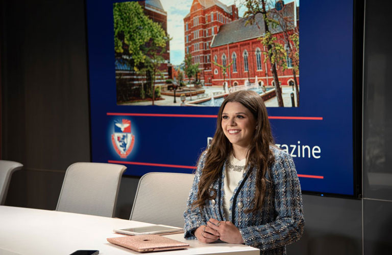 Student Baylee Martin sits at the news desk