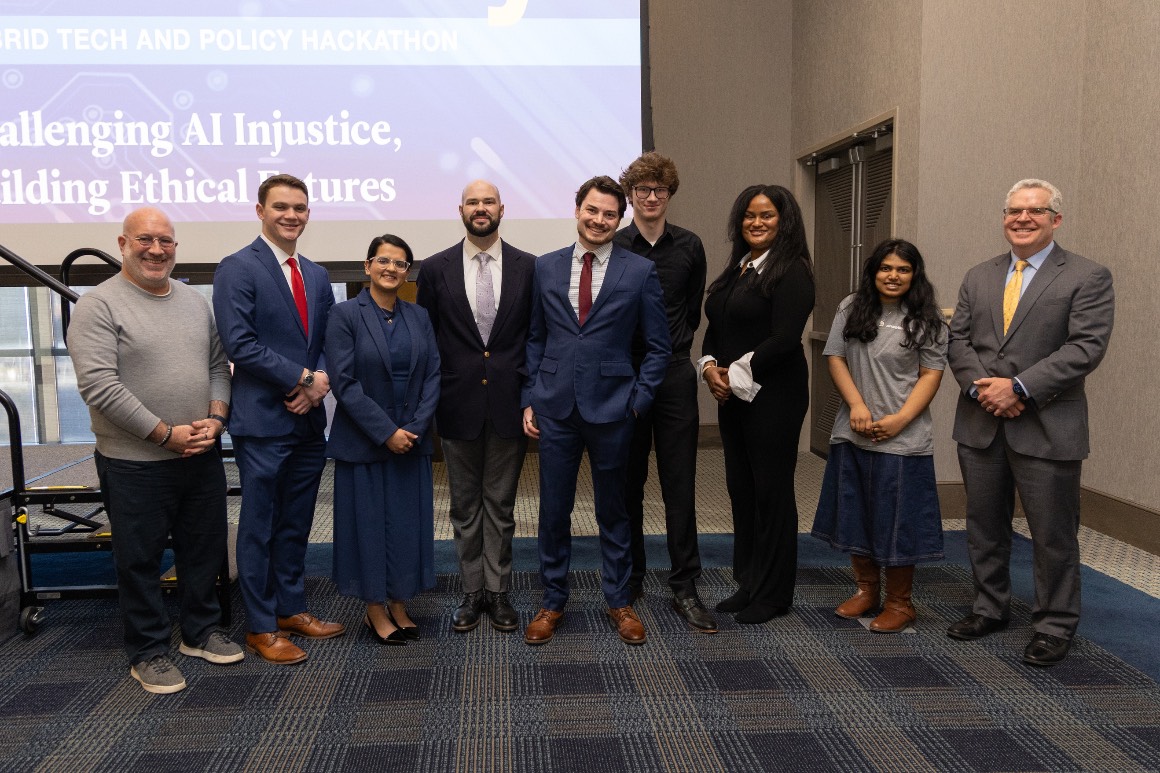 Hacking4Humanity 2026 tech and policy track winners pose for a photo with grefenstette center executive director John Slattery