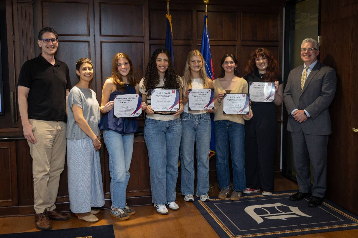 winners of the 2025-2026 young ethicist high school essay contest stand in a line holding their awards alongside their teacher and grefenstette center staff