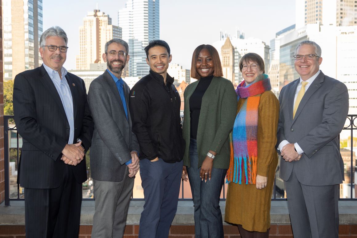 four panelists from the 2024 tech ethics symposium pose with president gormley and john slattery for group photo