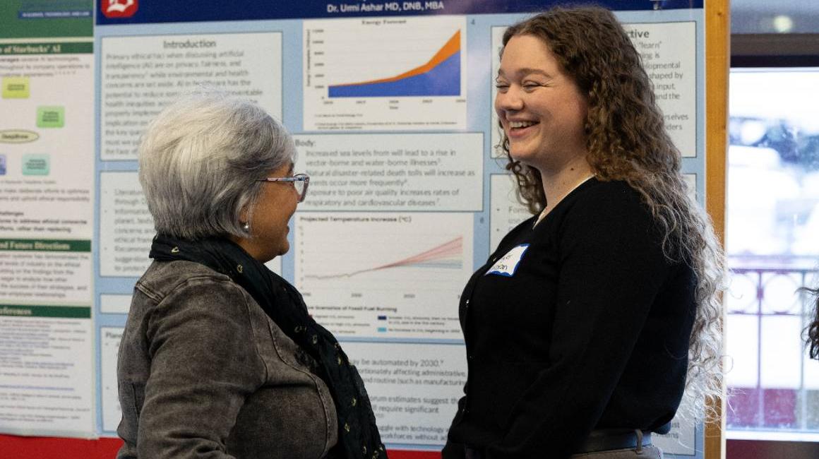 Student discusses poster with professor at the 2025 Tech Ethics Symposium