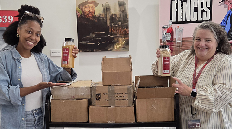 OCBE certificate graduates holding up spices at the McAnulty-Keating Food Pantry