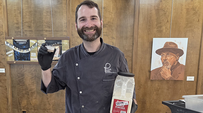 A man holding up spices at the McAnulty-Keating Food Pantry