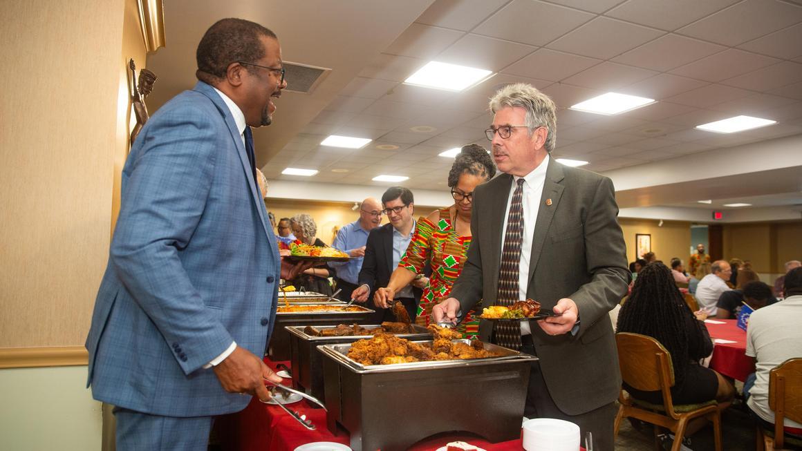 VP Bill Generett and President Gormley talk in the soul food line at Juneteenth 2025.