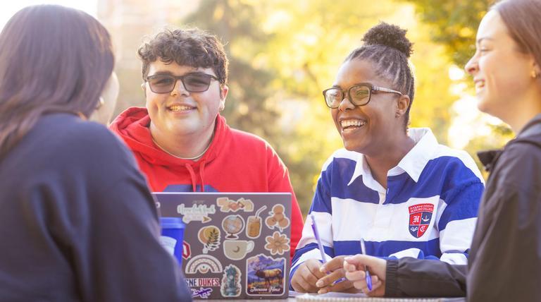 A group of students gathering outside on campus.